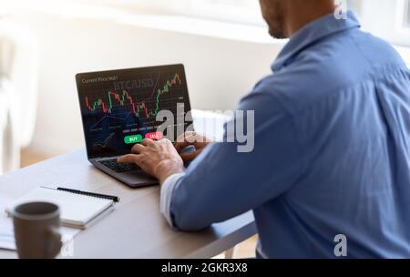 Unrecognizable black businessman working on laptop in office, trading online Stock Photo