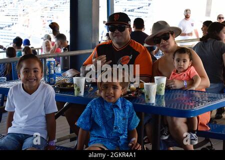 U.S. Navy Aviation Boatswains Mate (Fuel) 1st Class Anthony Leo, from American Samoa sits with his family during a Norfolk Tides baseball game at Harbor Park, for a Morale, Welfare and Recreation sponsored event, in Norfolk, Virginia, June 17, 2021. The John C. Stennis (CVN 74) is in Newport News Shipyard working alongside NNS, NAVSEA and contractors conducting Refueling and Complex Overhaul as part of the mission to deliver the warship back in the fight, on time and on budget, to resume its duty of defending the United States. Stock Photo