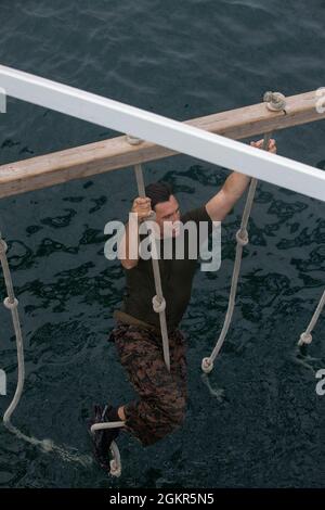 U.S. Navy Petty Officer 2nd Class Christian Aranha, a native of Orlando, Fla., with 2d Reconnaissance Battalion (2d Recon), 2d Marine Division, participates in a water obstacle during Exercise Caribbean Coastal Warrior on Savaneta Kamp, Aruba, June 18, 2021. The exercise allows 2d Recon to expand its knowledge and proficiency when operating in littoral and coastal regions while increasing global interoperability with 32nd Raiding Squadron, Netherlands Marine Corps. Stock Photo