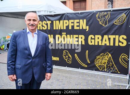 Berlin, Germany. 15th Sep, 2021. Entrepreneur Remzi Kaplan stands in front of a poster with the inscription 'ERST IMPFEN DANN DÖNER GRATIS'. As part of the creative vaccination, Berlin is also making low-threshold walk-in vaccination offers during the nationwide week of action. Those vaccinated there will receive a kebab voucher. Credit: Annette Riedl/dpa/Alamy Live News Stock Photo