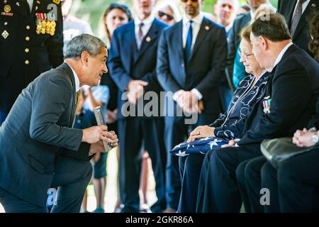 Kelly McKeague (left), director, Defense POW/MIA Accounting Agency (DPAA), presents a memento to Cecelia Sheridan at the conclusion of the funeral for her uncle, U.S. Army 1st Lt. Robert Charles Styslinger, in Section 60 of Arlington National Cemetery, Arlington, Virginia, June 18, 2021.    From DPAA:    In late 1950, Styslinger served with Battery B, 57th Field Artillery Battalion, 7th Infantry Division. He was reported to have been killed in action Nov. 29, 1950 while fighting enemy forces near Hagaru-ri, Chosin Reservoir, North Korea. His remains could not be recovered.    On July 27, 2018, Stock Photo