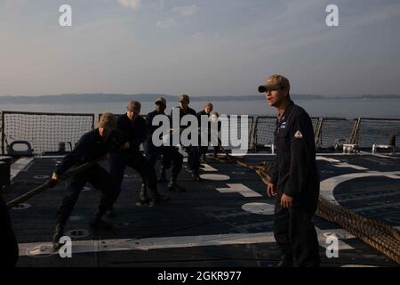 Eckernforde, Germany (June 19, 2021) Sonar Technician (Surface) 2nd Class Gabriel Pena gives orders to Sailors handling line during a sea and anchor evolution aboard the Arleigh Burke-class guided-missile destroyer USS Roosevelt (DDG 80), June 19, 2021. Roosevelt, forward-deployed to Rota, Spain, is on its second patrol in the U.S. Sixth Fleet area of operations in support of regional allies and partners and U.S. national security interests in Europe and Africa. Stock Photo