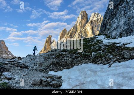 Hiker woman walking on path to majestic Croda Dei Toni mountain at dawn, Val Fiscalina, Sesto Dolomites, South Tyrol, Italy, Europe Stock Photo