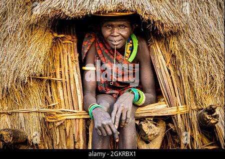 Scar face as a mark of beauty on woman from the Jiye tribe sitting in her hut, Eastern Equatoria State, South Sudan, Africa Stock Photo