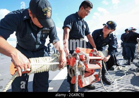 ROTA, Spain (June 19, 2021) Sonar Technician (Surface) 3rd Class Jonathan Salas, left, Fire Controlman (Aegis) 3rd Class Arthur Cataag, center, and Sonar Technician (Surface) 2nd Class Paige Jewett, assigned to the Arleigh Burke-class guided-missile destroyer USS Ross (DDG 71), prepare a pilot ladder to be stowed after leaving port at Naval Station Rota, Spain, June 19, 2021. Ross, forward-deployed to Rota, Spain, is on patrol in the U.S. Sixth Fleet area of operations in support of regional allies and partners and U.S. national security interests in Europe and Africa. Stock Photo