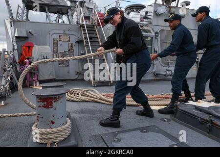 ROTA, Spain (June 19, 2021) Sonar Technician (Surface) 2nd Class Paige Jewett, left, Sonar Technician (Surface) 2nd Class Julian Nelson, center, and Sonar Technician (Surface) Seaman Apprentice Peoukinik Than, assigned to the Arleigh Burke-class guided-missile destroyer USS Ross (DDG 71), heave in a line to leave port at Naval Station Rota, Spain, June 19, 2021. Ross, forward-deployed to Rota, Spain, is on patrol in the U.S. Sixth Fleet area of operations in support of regional allies and partners and U.S. national security interests in Europe and Africa. Stock Photo