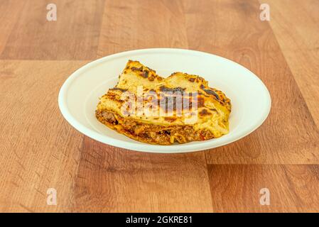 Minced meat lasagna with stewed tomato with béchamel sauce and melted cheese on a home delivery container Stock Photo