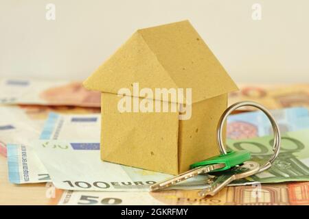 Origami recyled paper house and keys on money background - Concept of real estate and property investment Stock Photo