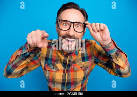 Photo portrait man staring happy wearing spectacles amazed selecting you isolated bright blue color background Stock Photo