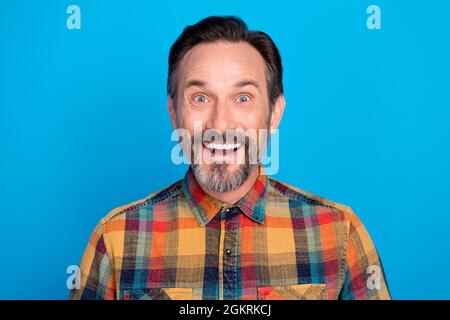 Photo portrait man staring amazed in plaid shirt smiling happy isolated vivid blue color background Stock Photo