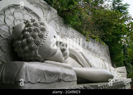 Carved sculpture of sleeping Buddha outdoors at Long Son Pagoda temple in Vietnam Stock Photo
