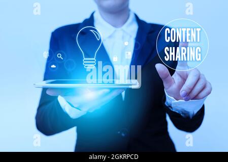 Hand writing sign Content Sharing. Word Written on distribution of webpage and blog content across social media Woman In Suit Holding Tablet Pointing Stock Photo