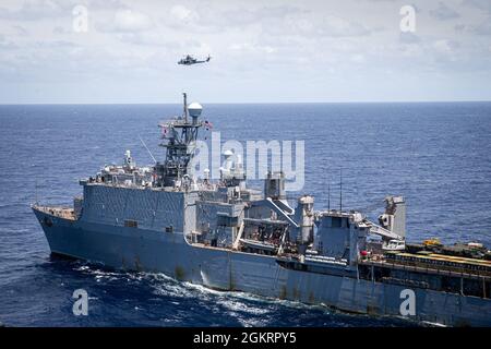 A U.S. Marine Corps UH-1Y Venom Helicopter transits to the USS Germantown (LSD 42) to conduct a Maritime Interdiction Operation (MIO) training exercise in the Philippine Sea, June 24, 2021. The MIO consisted of Force Reconnaissance Marines fast roping on to the USS Germantown and executing a search and seizure scenario with support from the Battalion Landing Team 3/5 as the security element. The 31st MEU is operating aboard ships of the America Amphibious Ready Group in the 7th fleet area of operation to enhance interoperability with allies and partners and serve as a ready response force to d Stock Photo