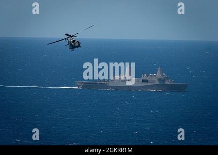 A U.S. Marine Corps UH-1Y Venom Helicopter transits to the USS Germantown (LSD 42) to conduct a Maritime Interdiction Operation (MIO) training exercise in the Philippine Sea, June 24, 2021. The MIO consisted of Force Reconnaissance Marines fast roping on to the USS Germantown and executing a search and seizure scenario with support from the Battalion Landing Team 3/5 as the security element. The 31st MEU is operating aboard ships of the America Amphibious Ready Group in the 7th fleet area of operation to enhance interoperability with allies and partners and serve as a ready response force to d Stock Photo