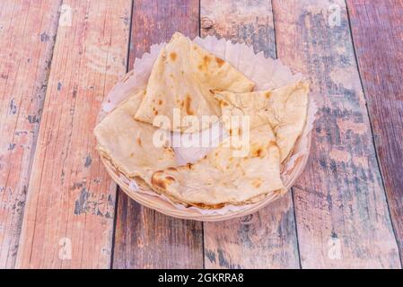 Chopped cheese naan placed in light wicker basket on wooden background Stock Photo