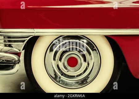 Retro styled image of the wheel of a red vintage American car Stock Photo