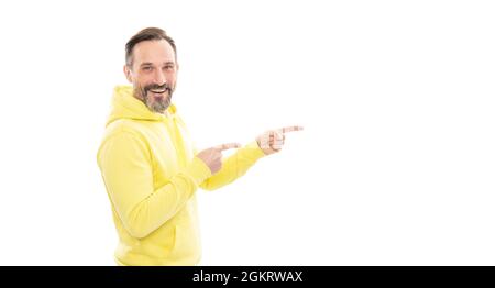 happy handsome mature man in hoody pointing finger on copy space isolated on white, presentation. Stock Photo