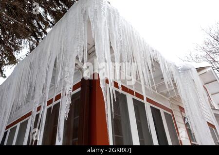 Hugh winter icicles hanging from the roof. St Paul Minnesota MN USA Stock Photo