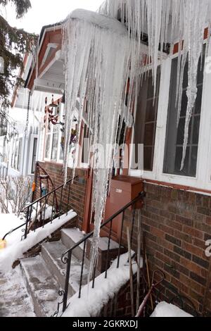 Large icicles at the front door hanging from the roof. St Paul Minnesota MN USA Stock Photo
