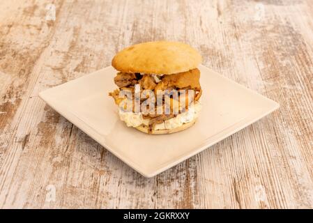 Spanish tapa of fried squid sandwich with aioli on square white plate Stock Photo