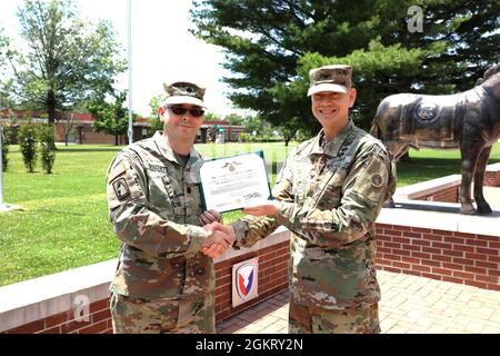 Col. Joseph Kurz, chief of staff, 1st Theater Sustainment Command, awards the Meritorious Service Medal to Lt. Col. Thaddeus Douthitt, fuel branch chief, 1st TSC, June 24, 2021 at Fort Knox, Kentucky. Douthitt's attention to detail, devotion to duty, and determination were instrumental in the success of the command's mission. Stock Photo