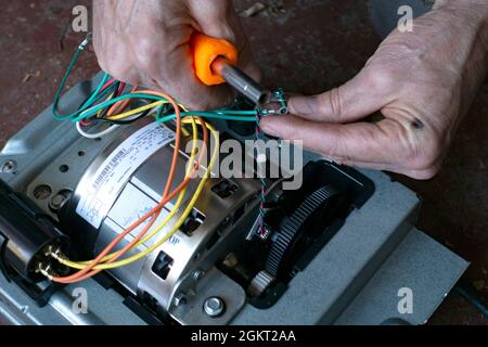 Working to repair the motor wiring on the garage door opener. St Paul Minnesota MN USA Stock Photo