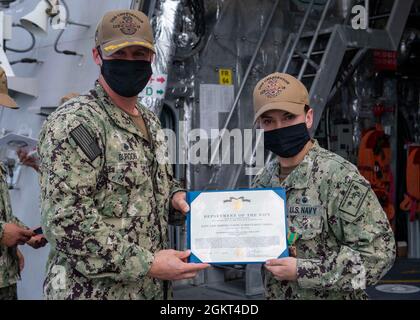 US Navy Engineman 2nd Class Anthony Bartelli (right) holds an