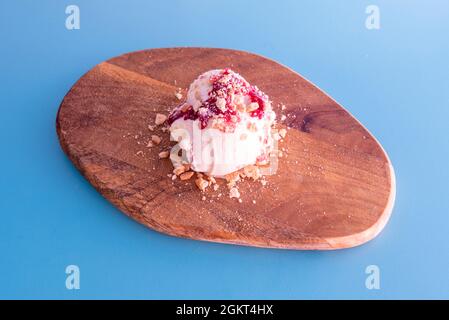 ball of cheesecake ice cream with red berry jam and cookie pieces Stock Photo
