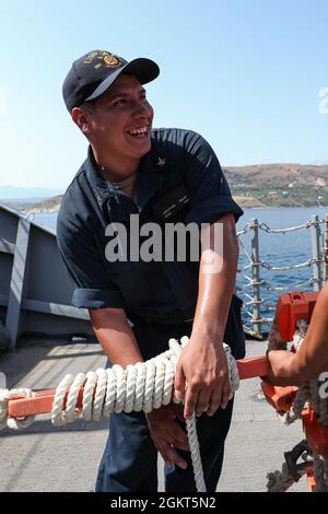 SOUDA BAY, Greece (June 25, 2021) Sonar Technician (Surface) 3rd Class Jonathan Salas, assigned to the Arleigh Burke-class guided-missile destroyer USS Ross (DDG 71), helps prepare a pilot ladder to be stowed as the ship leaves port in Souda Bay, Greece, June 25, 2021. Ross, forward-deployed to Rota, Spain, is on patrol in the U.S. Sixth Fleet area of operations in support of regional allies and partners and U.S. national security interests in Europe and Africa. Stock Photo