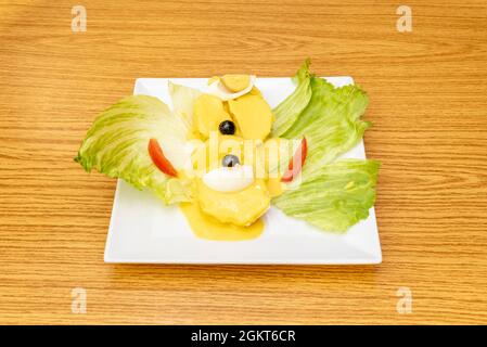 Popular recipe of Peruvian huancaina potato with lettuce leaves, boiled egg, black olives and all red tomato with yellow pepper sauce Stock Photo