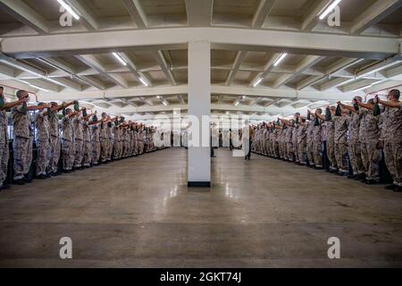 New recruits with Delta Company, 1st Recruit Training Battalion, participate in the pick up process at Marine Corps Recruit Depot, San Diego, June 25, 2021. Recruits were introduced to their drill instructors, and learned their rules and expectations for recruit training. Stock Photo