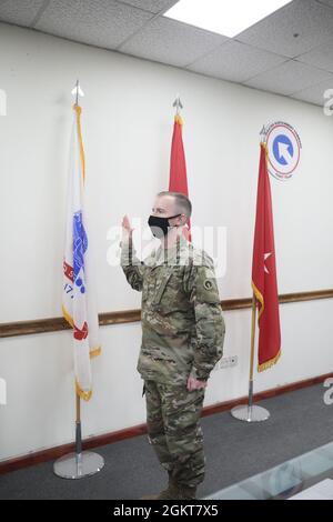 Maj. Timothy Ladwig, aide de camp, 1st Theater Sustainment Command, raises his right hand as he recites the Oath of Office during a frocking ceremony at Camp Arifjan, Kuwait, June 26, 2021. Ladwig stated he was thankful for the opportunity given to him by the 1st TSC. Stock Photo