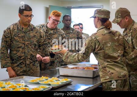 Staff Sergeant Elizabeth Pettek and Senior Master Sergeant David Hill, both with the 152nd Force Support Squadron, Nevada Air National Guard, serve lunch to Marines with the 6th Communication Battalion, Marine Forces Reserve, Brooklyn, New York, during Camp Paumalu IRT 2021 at the Girl Scouts of Hawaii’s STEM Center For Excellence at Camp Paumalu, Hawaii, June 28th, 2021. IRT Civil Engineer squadrons are constructing new cabins, demolishing old structures, and beautifying Camp Paumalu from May through August 2021, and rotating Force Support Squadrons will be providing three meals a day for the Stock Photo