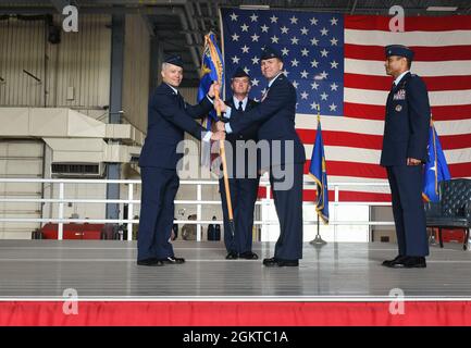 Lt. Gen. Timothy Haugh, 16th Air Force commander, receives the guidon from Col. Cameron Pringle, 319th Reconnaissance Wing outgoing commander, during the 319 RW change of command ceremony at Grand Forks Air Force Base, N.D., June 28, 2021. Base personnel were able to attend the ceremony while following COVID-19 precautions such as wearing a mask if not fully vaccinated. Stock Photo