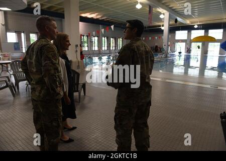 Lt. Gen. Timothy Haugh, left, 16th Air Force commander, and his wife Sherie Haugh, middle, are briefed by Master Sgt. San Juan Vasquez, Sustainment Services Flight superintendent about the fitness center swimming pool at Grand Forks Air Force Base N.D., June 28, 2021. He received the briefing during a tour of the installation while visiting Grand Forks AFB. Stock Photo