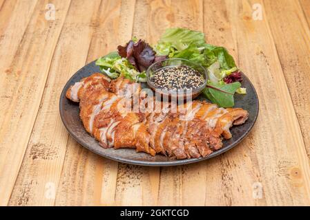 Duck dish cooked with cantonese duck recipe with sauce and assorted lettuce sprouts on wooden table Stock Photo