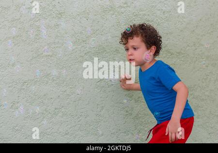 child playing in the playground with soap bubbles Stock Photo