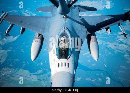 A U.S. Air Force F-16C Fighting Falcon from the 52nd Fighter Wing recieves air-to-air refueling from a KC-135 Stratotanker from the 100th Air Refueling Wing over the Baltic Sea region, June 29, 2021. Both aircraft supported a U.S. Air Forces in Europe - Air Forces Africa led Joint All-Domain Command and Control targeting exercise. The event was designed to train U.S. and ally forces to integrate, operate and communicate while executing all-domain operations. Stock Photo