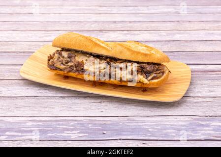 Great sandwich with lots of cheese Philadelphia mushrooms stewed on wooden plate Stock Photo