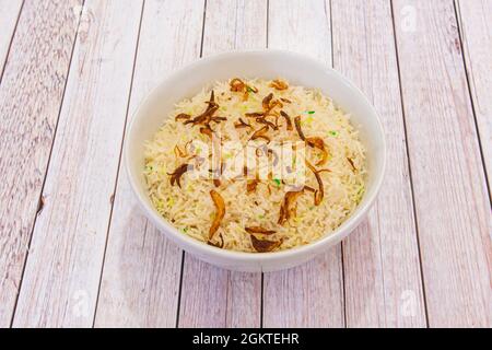 bowl of pilau basmati rice with brown onion cooked in Indian restaurant Stock Photo