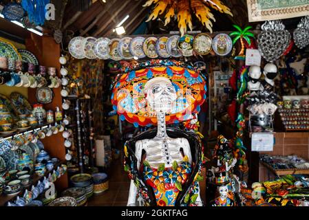 Mexican souvenirs of skull and ceramic plates at market shop Stock Photo
