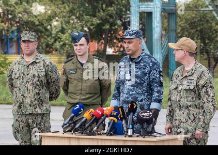 210630-N-BM428-0611 MYKOLAIV MILITARY AIRBASE, Ukraine (June 30, 2021) From left, Cmdr. Peter Mallory, U.S. Naval Attache to the U.S. Embassy Kyiv, Royal Canadian Air Force Capt. Alex Lavoie, Oleksiy Doskato, deputy commander of the Ukrainian Navy, and Capt. Stuart Bauman, senior officer from U.S. Sixth Fleet, answer questions from the media during an Exercise Sea Breeze 2021 air demonstration on Mykolaiv Military Airbase, Ukraine, June 30, 2021. Exercise Sea Breeze is a multinational maritime exercise cohosted by the U.S. Sixth Fleet and the Ukrainian Navy since 1997. Sea Breeze 2021 is desig Stock Photo