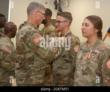 SINAI PENINSULA, Egypt - Col. Scott Sentell (left), the Task Force Sinai brigade commander, pins an award on Sgt. Matthew Brewer, a laboratory technician currently assigned to Medical Company, Task Force Sinai, for his efforts during his service as part of the Multinational Force and Observers at an end of tour ceremony held at the South Camp, South Sinai, Egypt June 30, 2021. Stock Photo