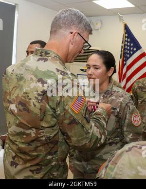 SINAI PENINSULA, Egypt - Col. Scott Sentell (left), the Task Force Sinai brigade commander, pins an award on Maj. Love Hartman, a transportation officer currently assigned to Headquarters and Headquarters Company, Task Force Sinai, for her efforts during her service with the Multinational Force and Observers at an end of tour ceremony held at the South Camp, South Sinai, Egypt June 30, 2021. Stock Photo