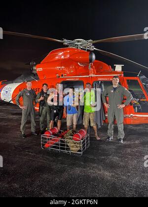 Air Station Miami crew are with the two rescued people and their dog at Martin County Airport in Stuart, Florida June 30, 2021. The aircrew hoisted the two people and their dog off a life raft after their vessel sank near Jensen Beach, Florida. Stock Photo