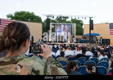 An audience records U.S. Air Force Gen. John E. Hyten (right), vice chairman of the Joint Chiefs of Staff, and Taylor Williamson, comedian, performing on stage during the USO Summer Tour, July 1, 2021, at Joint Base San Antonio-Lackland, Texas. The USO brings shows to hundreds of thousands of American service members around the world. This is the first in-person event since the beginning of the COVID-19 pandemic impacted U.S. service members worldwide. Stock Photo