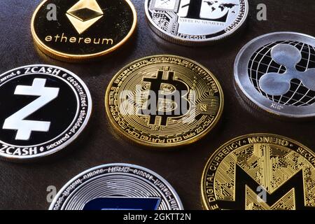 Bitcoin, litecoin and ripple coins currency .Virtual money represented by real coins placed against a dark background. Golden bitcoin in the middle. Stock Photo