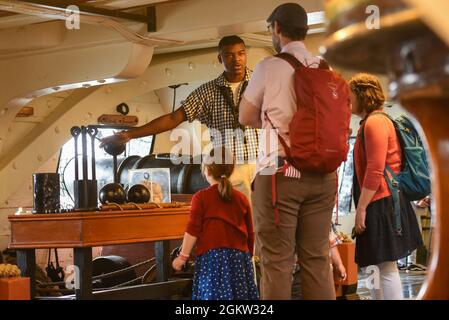 Airman Jabari Shabazz, from Atlanta, GA, shares the history of the USS Constituion with passengers underway in Boston, Massachusetts, on July 4th, 2021. The USS Constitution got underway in commemoration of the 245th Independence Day. Stock Photo