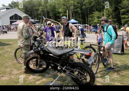 Cyclists are introduced to an Army Zero FX Z-Force 5.7 Electric Motorcycle during the Fourth of July NASCAR Cup Series race at Road America, Elkhart Lake, Wisconsin, July 4, 2021. The U.S. Army recruiting battalion, along with the Appleton Recruiting Company brought recruiters and displays from across their area to meet with citizens, allow them to experience Army technology and evaluate opportunities in military service. Brig. Gen. Ernest Litynski, Commanding General, 85th U.S. Army Reserve Support Command, attended the race as the Army’s senior leader and swore in 20 future Soldiers at the p Stock Photo