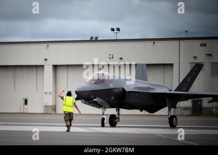 U.S. Air Force Staff Sgt. Michael King, a 356th Aircraft Maintenance Unit crew chief, marshals an F-35A Lightning II assigned to the 355th Fighter Squadron during a hot pit refuelling on Eielson Air Force Base, Alaska, July 7, 2021. As a crew chief, King is responsible for performing special pre- and post-flight aircraft inspections to ensure pilots can safely and effectively complete their mission. Stock Photo